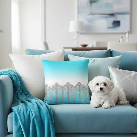 A square throw pillow featuring a printed design of a silver Art Deco style gate against a turquoise and white gradient background.