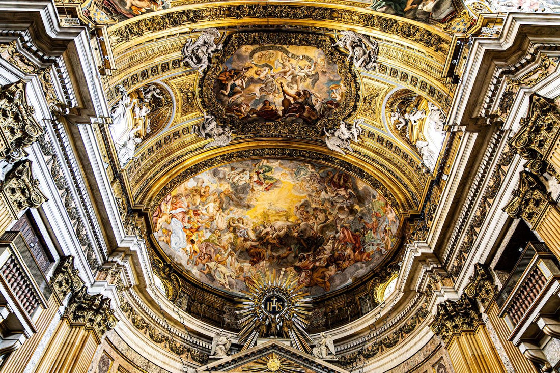 Baroque ceiling fresco at the Church of the Gesù in Rome, gilded stucco surrounding a painted sky of dramatic figures.
