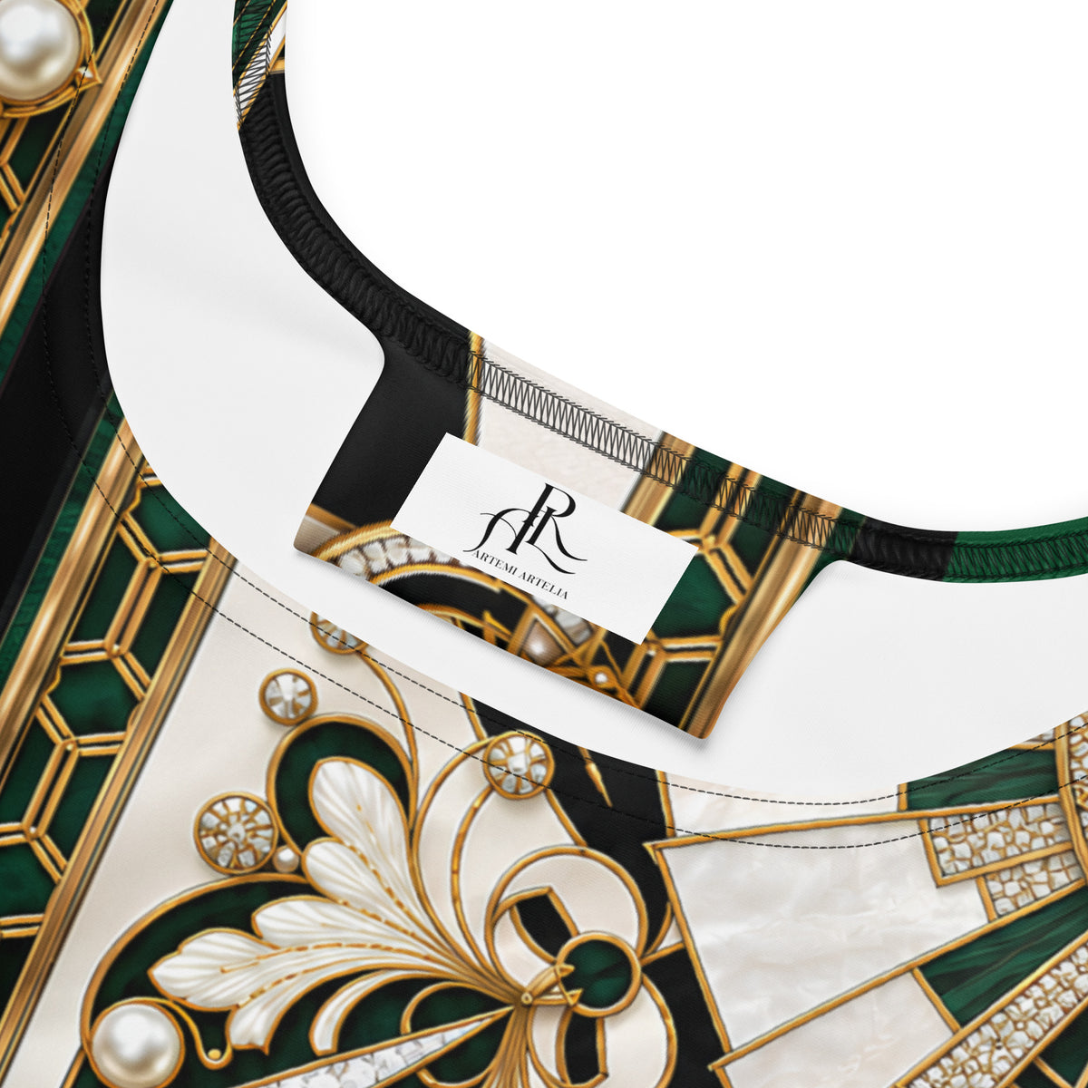 Close-up of a luxury print dress featuring a bold Art Deco pattern in emerald green, gold, and white, with a visible 'ARTEMI ARTELIA' brand tag.
