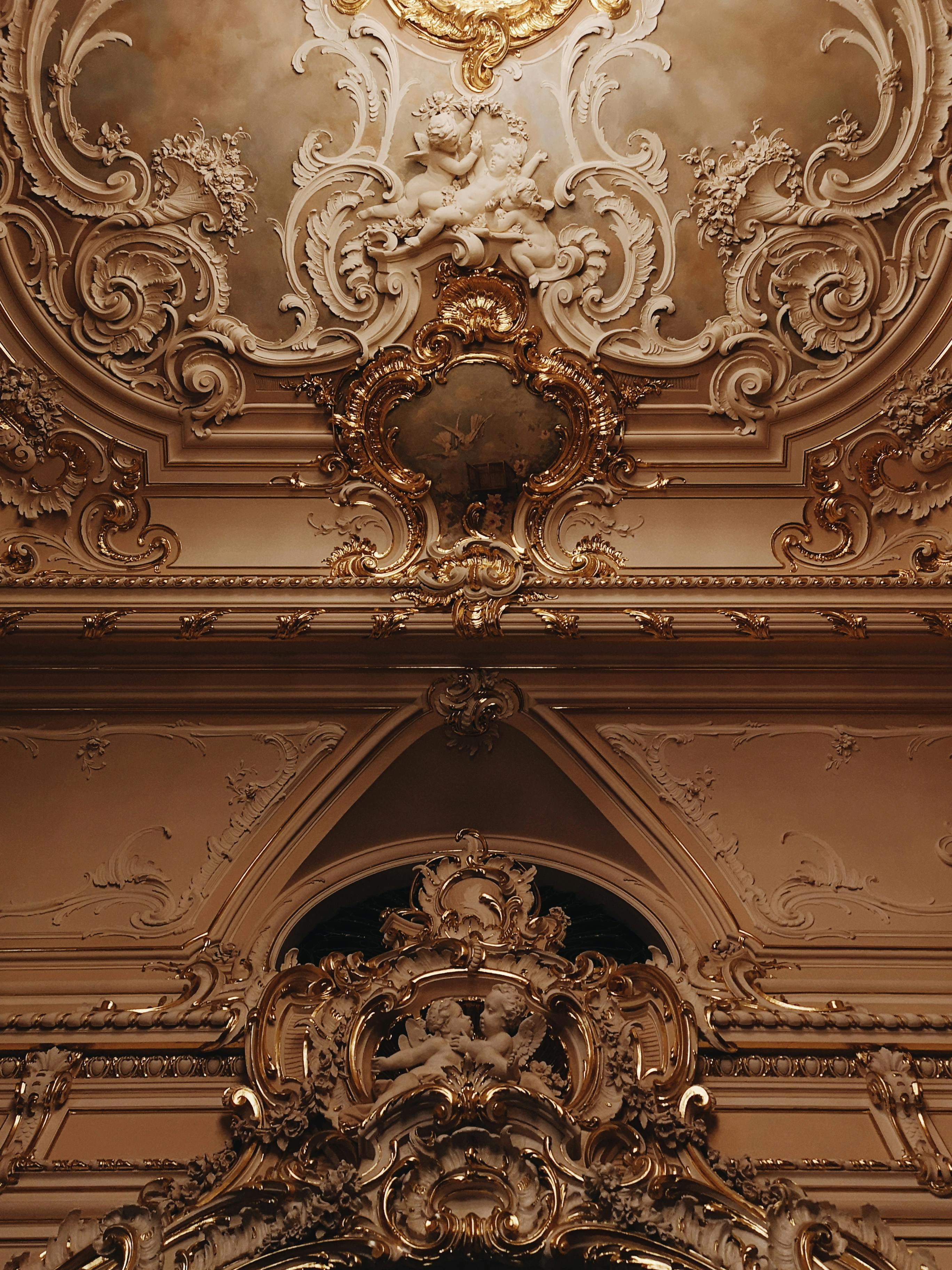 Intricately designed Baroque style ceiling with rich ornamentation and classical sculptures.