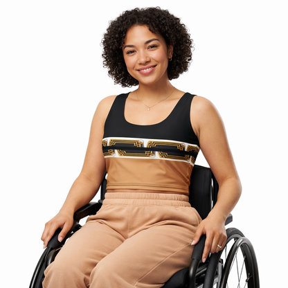 A young girl with curly hair, seated in a wheelchair, wearing a black and beige top featuring Egyptian Revival Art Deco pharaoh motifs — an original design by ARTEMI ARTELIA — on a white background.