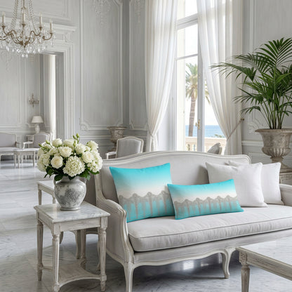 A square throw pillow featuring a printed design of a silver Art Deco style gate against a turquoise and white gradient background. Stylishly displayed in an elegant french hotel interior.