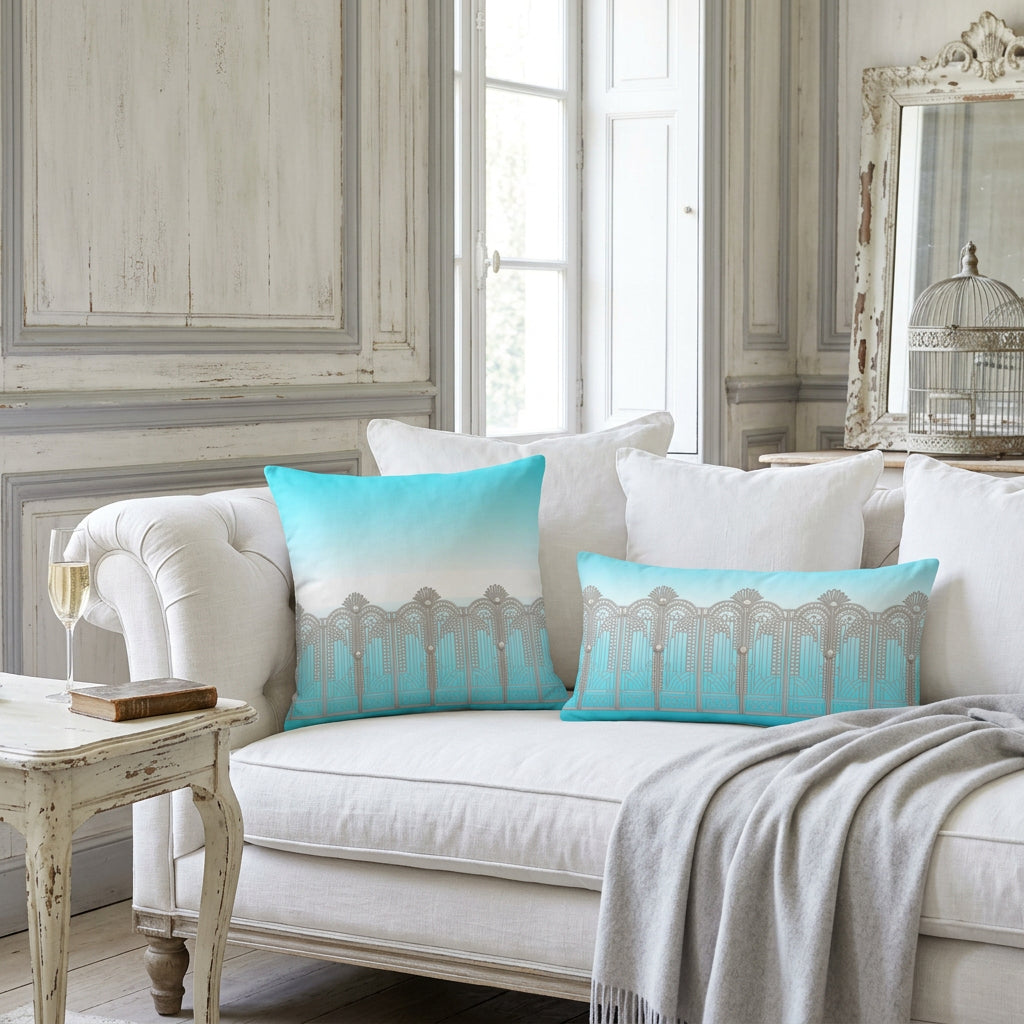 A square throw pillow featuring a printed design of a silver Art Deco style gate against a turquoise and white gradient background.