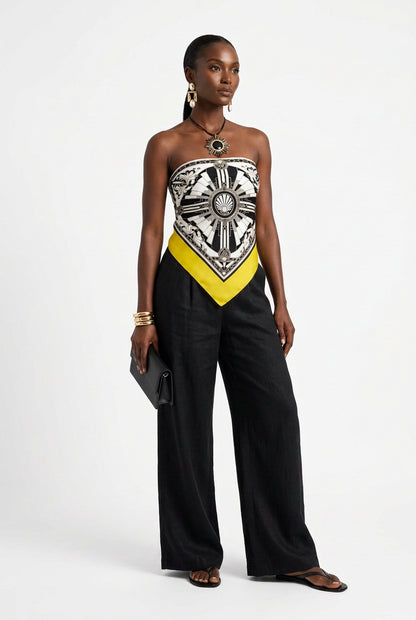 A square scarf featuring a bold Art Deco style design in black, white, and bright yellow. The center has a detailed geometric and ornamental pattern with a scallop shell motif in the middle, bordered by a wide yellow band and a black outer border with yellow corners.