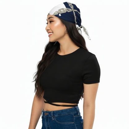Navy and white polka dot headscarf styled on a woman wearing a black crop top and blue jeans, on a white background.