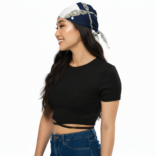 Navy and white polka dot headscarf styled on a woman wearing a black crop top and blue jeans, on a white background.