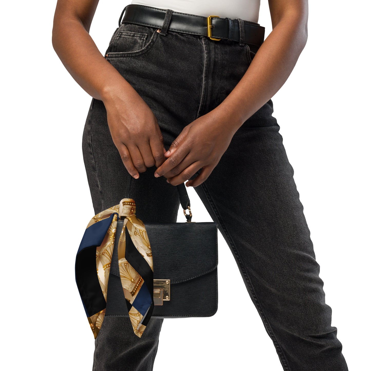Person holding a black handbag with a decorative scarf, wearing black jeans and a white top.