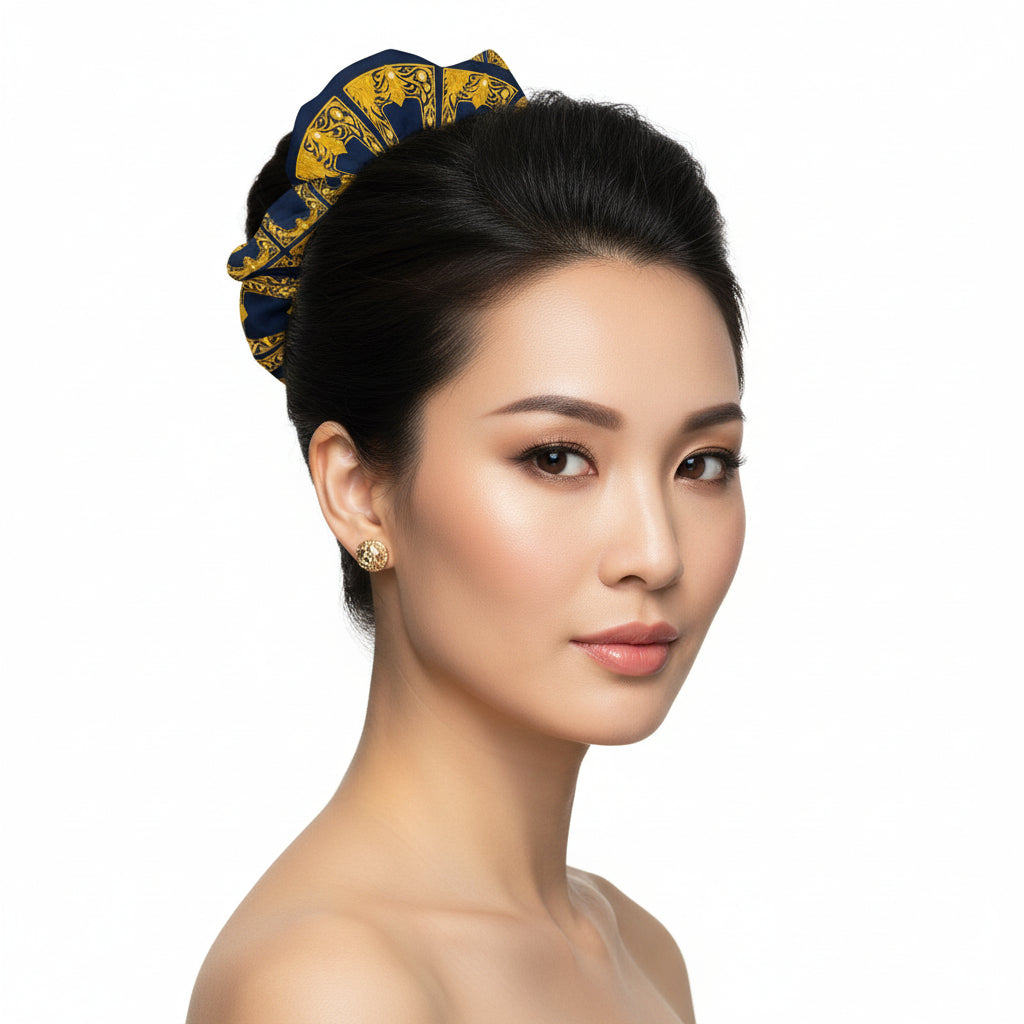 An Asian model with black soft hair elegantly tied into a bun with a scrunchies featuring a gold Baroque frame pattern on navy recycled material.