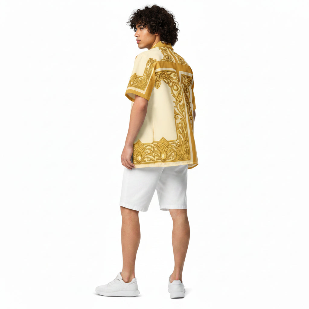A model shown from the back wearing a cream-colored short-sleeve button-up shirt with a prominent gold ornate pattern, paired with white shorts and white sneakers, set against a plain white background.