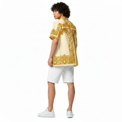 A model shown from the back wearing a cream-colored short-sleeve button-up shirt with a prominent gold ornate pattern, paired with white shorts and white sneakers, set against a plain white background.